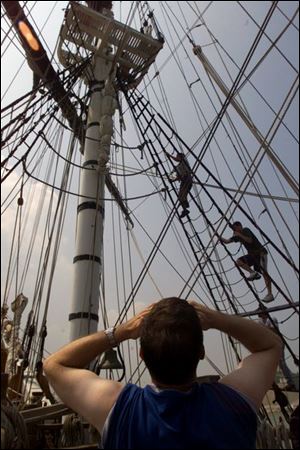 A tourist on the Bounty watches Luke Elliott, top, and Mitchell Bandklayder practice climbing the rigging on their second day of training. The ship was in Fairport, Ohio.