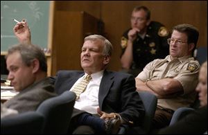 Prosecutor Dan Pilrose, center, questions a witness as defense attorney Sol Zyndorf, left, and Lucas County Dog Warden Tom Skeldon listen to the court proceedings.
