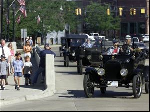 Model T Fords cross the River Raisin bridge in Dundee en route to the Old Mill Museum, where drivers had breakfast.