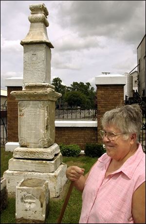 `We just told them there's a surprise,' says Helen Kaverman, a cemetery board member, speaking of the kin of Delphos' founder. Next to her stands the newly discovered 145-year-old monument to the Rev. John Otto Bredeick the family members will see on their visit on Aug. 1.