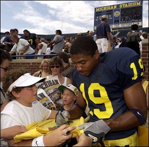 Willis Barringer signs autographs yesterday for Michigan fans on photo day - as a safety, not a cornerback.