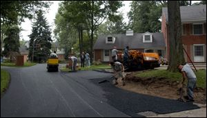 Jennite employees work on a driveway. The Toledo company does paving and sealing.