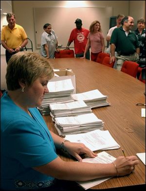 Karen Poore counts the signatures, above, on petitions seeking a referendum on Toledo's anti-smoking ordinance. 