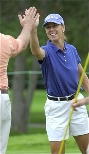 Laurel Kean gets a high-five after sinking a putt in the Fifth Third Bank Pro-Am.