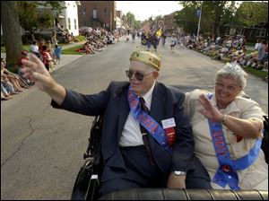 Calvin and Evelyn Gerwin wave to the crowds on Front Street as they lead the children's parade from the rear of Tom Ward's 1924 Model T Ford. The Freedom Township couple were crowned king and queen of the Pemberville Free Fair.