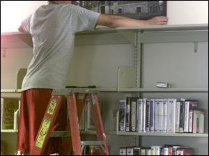 Mike D'Agastino, who will be in Ida High School's 100th graduating class in 2007, hangs a print of the first school.
