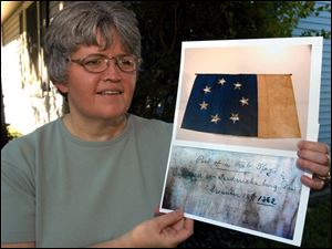 `I'm just kind of an accident that started it,' says Meri Schoof, with photos of the flag and the writing on the back of it.