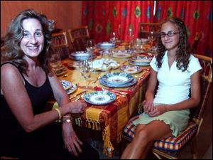 Mary Ellen Pisanelli and one of her daughters, Lia, at the table set with Italian china.
