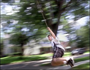 ROV HIGH FLIER 8/19/03 PHOTO BY LORI KING John Brown, 17, uses climbing rope to swing around a tree in his neighbor's front yard on Gunckel Blvd. Brown and his best friend Isaac Weintraub,16,  spend the summer days swinging from tree limbs for fun.