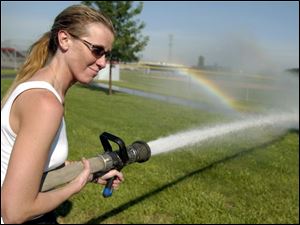 CTY drill19p 02 - Dorothy Lemecha, a St. V's Emergency Medicine resident learns the correct way to hold a fire hose during a training exercise at Owens Community College fire science and Law enforcement center. The Blade/Allan Detrich