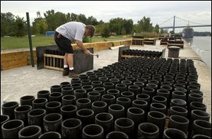 Bob Smith, vice president of Colonial Fireworks of Clayton, Mich., prepares some of the nearly 3,000 mortar tubes that would come into play during the finale of the Toledo fireworks display along the Maumee River in International Park.