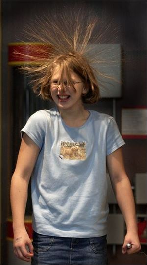 rov hair03p 1 September 3, 2003. Faith Hay, 11, of Fremont, O., uses a Vande Graff generator at Cosi to produce static electricity. Blade photo by Jeremy Wadsworth