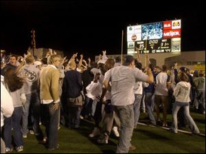 Fans rush the field at the Glas Bowl after Toledo's win over the University of Pittsburgh.