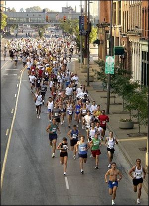 Runners race through the streets of downtown Toledo yesterday in the Blade Classic 10K. More than 370 runners participated in the annual event.