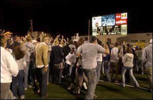 Fans rush the field at the Glas Bowl after Toledo's win over the University of Pittsburgh.