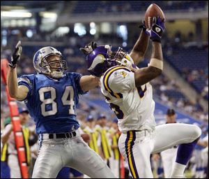 Minnesota's Denard Walker, right, picks off a pass by Detroit's Joey Harrington in the end zone in the game's final minute, one of three interceptions for the Vikings.