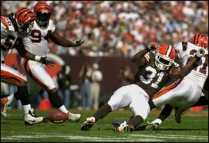 Cleveland's William Green fumbles after a hit by Cincinnati's Jeff Burris, right. The Browns' Jeff Faine recovered, but other mistakes could not be overcome as Cleveland fell to 1-3