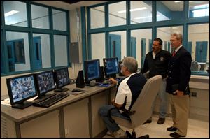 Sgt. Tad Kluck, Dale Mitchell, director of detention, and Judge Brad Culbert of Sandusky County Juvenile Court view the computerized control room of the new detention center.