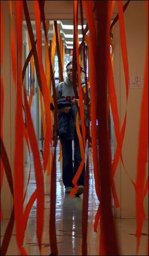 Bowling Green State University Student Bridget Tharp, junior in Journalism, makes her way  down a hallway of streamers decorated for the Homecoming Spirit Decorating Contest by the staff at Tucker Center for Telecommunications. Various contests are being held throughout the week to build spirit for the big football game on Saturday. Lisa dutton 09/30/2003 ROV  BGSU Streamers