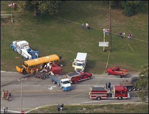 Emergency crews get the children off the bus after it collided with the tractor-trailer rig Oct. 10, 2002, while on its way to an outing at Erie Orchards & Cider Mill.