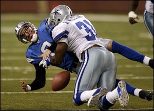 Lions quarterback Mike McMahon takes a hit from Dallas' Roy Williams while trying to recover his own fumble.