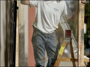 ROV framed 01 - John Ortyl, an overall handyman and painter, does some odd jobs for Bijou owner Kip Diacou as he paints some of the frames of the dispalays on the outside of the nightclub on Superior St. The Blade/Allan Detrich
