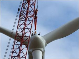Reg  wind23p  Wood County Landfill area.  Two workers hail the crane operators on the ground from the top of the windmill.   Diane Hires  10/23/03