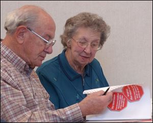 Toledo seniors Francis and Melva Fry look over literature during a driving course at MCO's Collier Building.