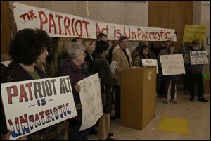 Toledo City Councilman Peter Gerken speaks during a news conference at Government Center while demonstrators display a banner and signs protesting the USA Patriot Act.