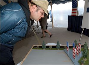 Jeff Exton, who works at the Lima Army Tank Plant, views a model of the monument to be built outside the plant. Officials hope to have it completed by Veterans Day next year.