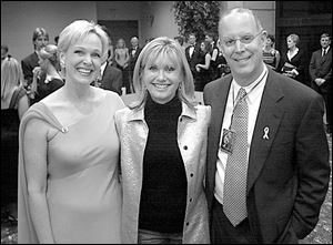 Singer Olivia Newton-John is flanked by Chrys Peterson and Jeff Jaffe, co-chairmen of the Pink Ribbon Gala.