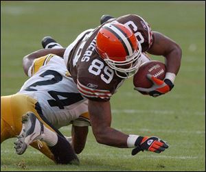 Browns tight end Darnell Sanders, right, reaches for extra yardage when tackled by Pittsburgh's Ike Taylor.