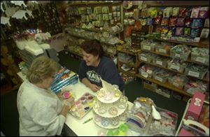 Pam Hovey, left, assists Sandy Cutcher select cake decorations at Cake Arts Supplies, 2858 West Sylvania Ave.