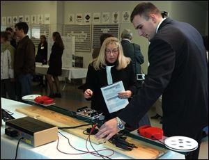 Debbie Whitcum of Elmore,OH listens to Nathan Rose as he explains how the Reverse Guiding System works during the Senior Design Engineering Project Exposition at the University of Toledo College of Engineering. Lisa dutton 12/12/2003 CTY design12p 1