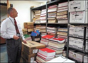 Mayor John Quinn surveys boxes and stacks of records in the copy machine room at Bowling Green City Hall. Documents for the personnel, finance, and mayor s offices are stored in the room.