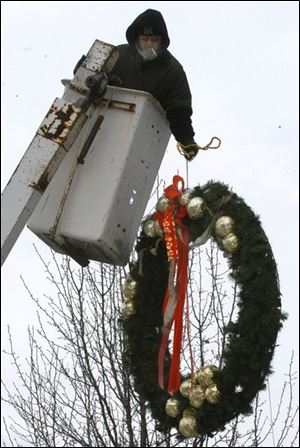 Rov Tom Moore, of Tom Moore signs,  removes xmas decorations from Georgio's. blade photo   by herral long 1/8/2004