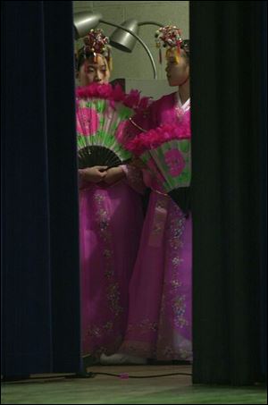 CTY KOREAN08P 2 1/8/03 PHOTO BY LORI KING Two of the dozen or so girls from the Kidz Chorale, of Korea, wait behind the stage curtain to be introduced for their performance during parent meeting at Toledo Christian School.
