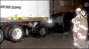 A car is wedged under a tractor-trailer rig after a pileup on southbound I-75. The driver was not seriously injured.