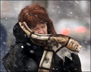 Eileen Hoye battles the wind and blowing snow as she heads back to work after lunch in downtown Toledo.
