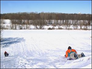 Nbr  snow25p  Ft. Meigs sledding hill.  Sledders have a great ride - It was only 12 degrees out and  the snow was fast.  Diane Hires  1/24/04