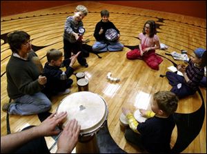 FEA drum07p 01 - L-R, Nancy Smith, Alex Dodson, Connor Tullis, Penny Tullis, Andie Lieberman, Elizabeth Tullis and Edward Lammie, join in a drum circle at St. Marks Episcopal Church on Collingwood Ave. Allan Detrich/The Blade