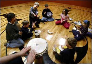 FEA drum07p 01 - L-R, Nancy Smith, Alex Dodson, Connor Tullis, Penny Tullis, Andie Lieberman, Elizabeth Tullis and Edward Lammie, join in a drum circle at St. Marks Episcopal Church on Collingwood Ave. Allan Detrich/The Blade