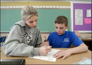 Jesica Justafson, left, works with fifth grader Devin Barnaby in Swanton Local s Park Elementary School. Voters will be asked to adopt a 1.25 percent income tax.