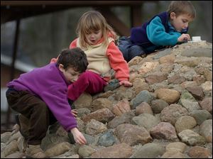 Nbr  Burnham Park, Sylvania, Ohio.  l-r  Jonah Kadens 5, Grace Cappellini 4, and Owen Cappellini 6, look for pennies stuck in the rock crevices of the fountain in the park.  The fountain is shut off for the winter - the kids arent getting rich, but its fun like a treasure hunt.  Diane Hires  1/3/03