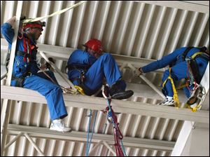 Cty Photo by Don Simmons Feb 20, 2004  In the  rafters of Saint Agnes School located on Martha Ave. is L to R  Lt Bob Klever, Mike McBride, and Dave Balogh as they get ready to repel down to the floor