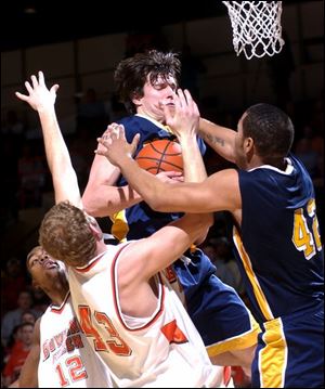 Toledo s Allen Pinson grabs a rebound between Bowling Green s Ron Lewis, left, and Cory Eyink and UT s Florentino Valencia. The Rockets are 16-9, 10-6 in the MAC. BG is 13-13, 8-7.