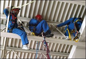Cty Photo by Don Simmons Feb 20, 2004  In the  rafters of Saint Agnes School located on Martha Ave. is L to R  Lt Bob Klever, Mike McBride, and Dave Balogh as they get ready to repel down to the floor