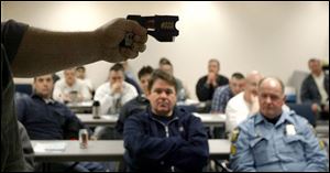 Toledo police officers are taught how to use the smaller, lighter Tasers at the department's Scott Park district station.