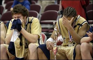 After the game, Mickey Cassidy and Brian Roberts of St. John's sit dejected with the state basketball runner-up trophy.