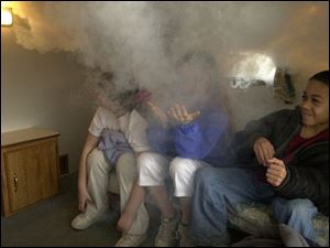 ROV SMOKE HOUSE 3/29/04 PHOTO BY LORI KING Starr Elem. School 3rd grader Devon Tufts (R) reacts to smoke filling a miniature-sized bedroom inside the Fire Safety House, where they learned to stop, drop and roll, call 911 and plan escapes. The students were among about 120 Starr kindergartners and 3rd graders who were taught today fire safety as part of the Safe Kids Coalition from the Toledo Hospital. Oregon firefighters were on hand for the instruction. Two students on the left are unidentified.